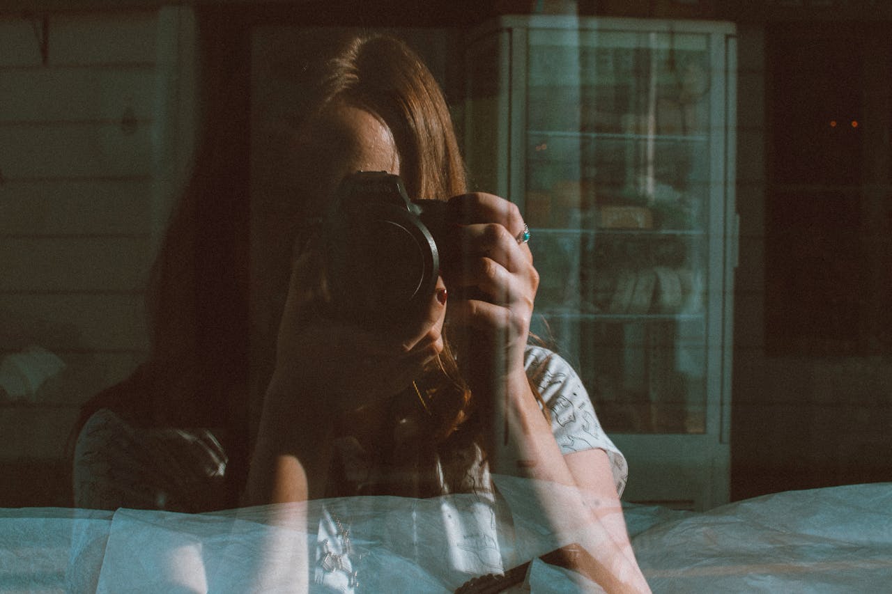 Frau fotografiert sich in Scheibe